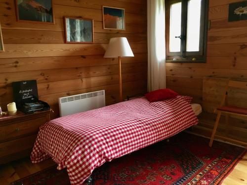 - une chambre avec un lit et une couverture rouge en damier dans l'établissement Grand Pra, à Les Haudères