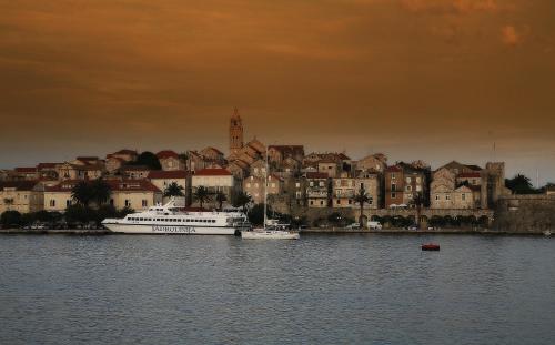 a boat in the water in front of a city at Marina Guesthouse in Korčula