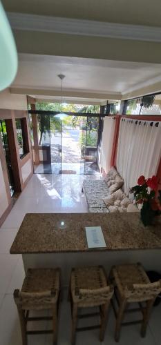 a room with a counter and two stools and a table at Hotel Ferrugem Eco Village in Garopaba