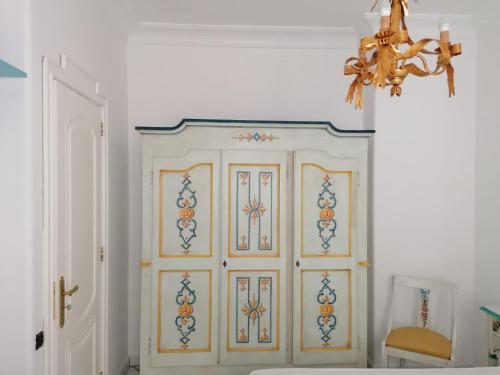 Cette chambre est dotée d'une porte blanche et d'un lustre. dans l'établissement La casa di Rosa (Appartamento con terrazzo panoramico nel Cuore di Sorrento), à Sorrente