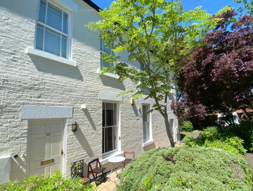 a white brick house with a white door at Fabulous 2 bed Historic Ground floor apartment Belper with free car parking next to property in Belper