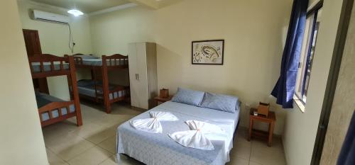 a small bedroom with a bed and a bunk room at Hotel Ferrugem Eco Village in Garopaba