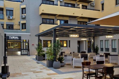a patio with tables and chairs in front of a building at Turial Old Town Ocean View in Albufeira