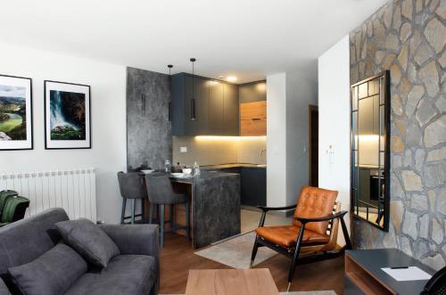 a living room with a couch and a kitchen at Zlatibor Residence & Suites in Zlatibor