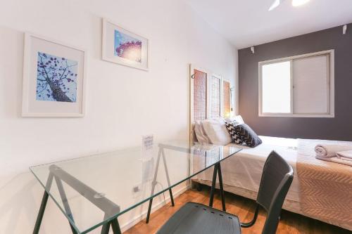 a dining room with a glass table and a couch at Apartamento espaçoso em Pinheiros ao lado do metrô in Sao Paulo