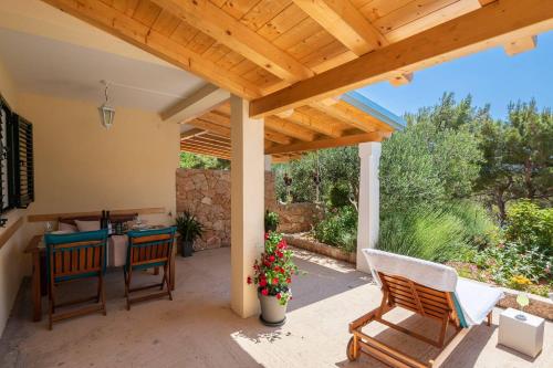 a patio with a wooden pergola and a table and chairs at Apartments Silvana in Sveta Nedelja