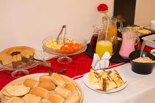 a table topped with plates of bread and orange juice at Hotel Granny in Tarija