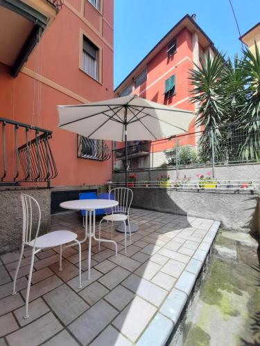 a table and chairs with an umbrella on a patio at Maison d' Ofelia in Chiavari