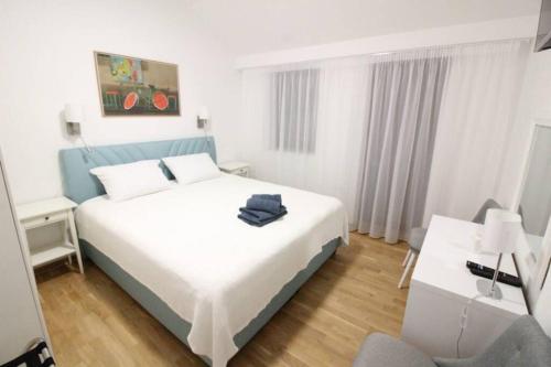 a bedroom with a large white bed and a chair at WATERFRONT VILLA SUNSET DREAM WITH POOL in Trebinje
