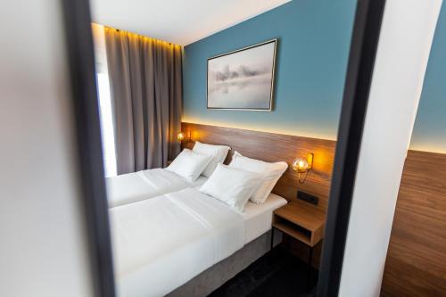 a hotel room with two beds and a mirror at Boutique ROOMs 76 in Imotski