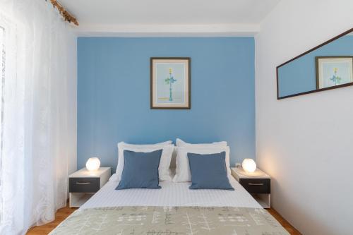 a blue bedroom with a bed with blue walls at Villa Gradina in Vela Luka