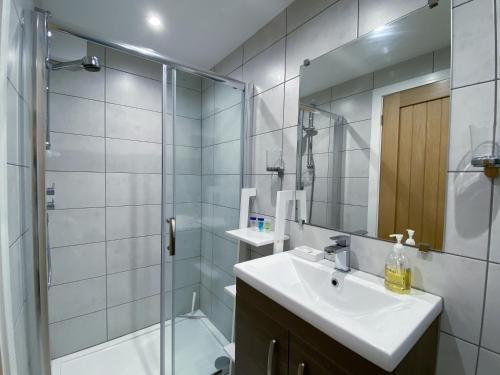 ein Bad mit einem Waschbecken und einer Dusche mit einem Spiegel in der Unterkunft THE STUDIO MAIDENHEAD RIVERSIDE in Maidenhead