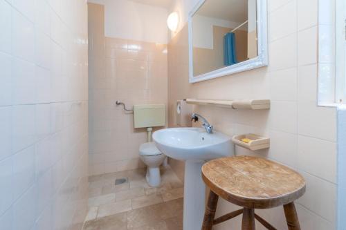 a bathroom with a sink and a toilet and a mirror at Villa Gradina in Vela Luka