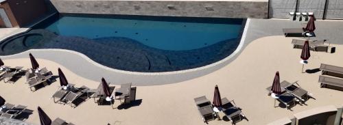 an overhead view of a swimming pool with chairs and umbrellas at Hotel Baffo Rosso in Alba Adriatica