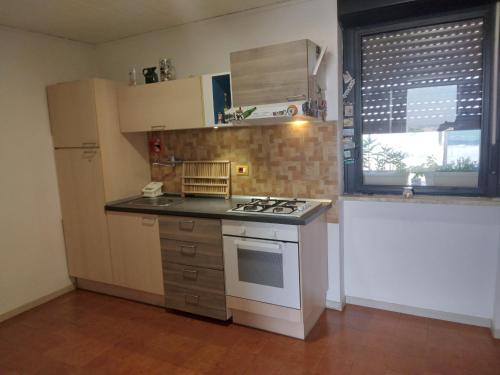 a small kitchen with a stove and a window at Piccolo Attico in Lecce