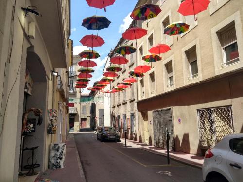a row of red umbrellas hanging over a street at Number15 Guesthouse Carcassonne in Carcassonne