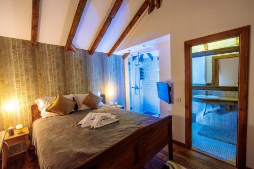 1 Schlafzimmer mit einem großen Bett und einem Badezimmer in der Unterkunft Woodland Resort in Kragujevac