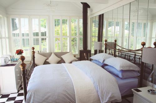 a bedroom with a bed with white and blue pillows at Croft House Guest Suite Painswick in Painswick