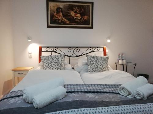 a bedroom with two beds with white sheets and pillows at Malom Vendégház Tapolca in Tapolca