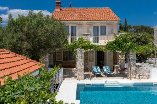 a villa with a swimming pool and a house at Villa Gradina 01 in Vela Luka