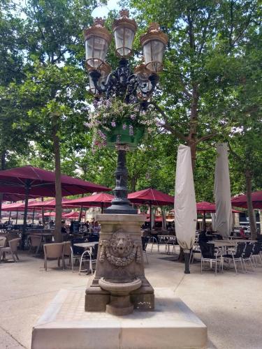 a street light in a courtyard with tables and umbrellas at Number15 Guesthouse Carcassonne in Carcassonne