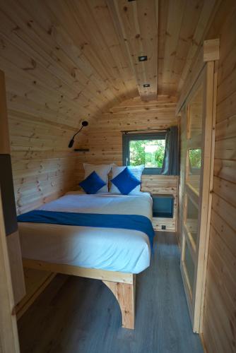 une chambre avec un lit dans une cabane en bois dans l'établissement Camping Les Prés du Roi, à Sommières