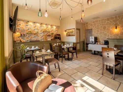 a restaurant with tables and chairs and a dining room at Altera Roma Hôtel in Avignon