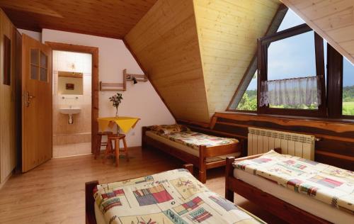 a attic room with two beds and a sink at Pensjonat Lesniczówka bieszczady solina polańczyk in Polańczyk