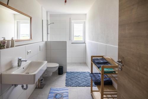 a white bathroom with a sink and a toilet at Ferienwohnung Häfele 1 in Bad Wurzach