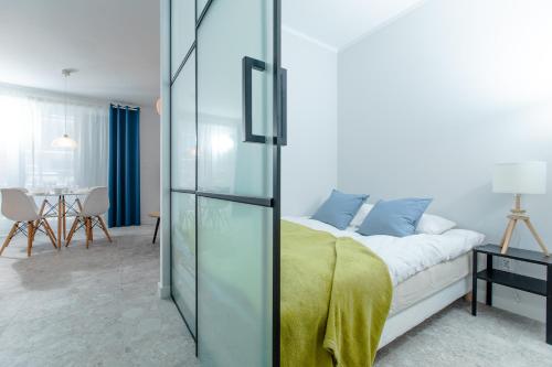 Schlafzimmer mit einem Bett mit Glaswand in der Unterkunft Resort Apartamenty Klifowa Rewal 59 in Rewal