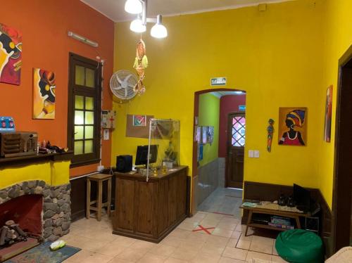 ein Wohnzimmer mit gelben Wänden und einem Kamin in der Unterkunft Malecon en calle Techada Hostel in Capilla del Monte