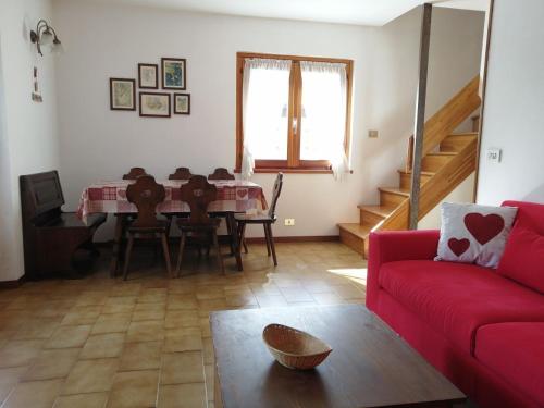 uma sala de estar com um sofá vermelho e uma mesa em Appartamento TEMELIN em Bormio