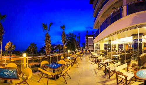 a patio with tables and chairs at night at Eftalia Down Town in Alanya
