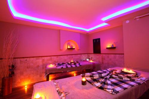 two beds in a room with purple lights at Eftalia Down Town in Alanya
