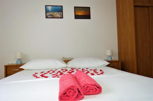 a bed with two pink towels on top of it at Apartment West in Makarska