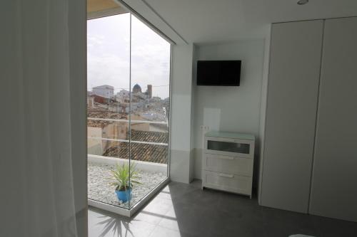a living room with a large window and a tv at Hostal Fornet Altea in Altea