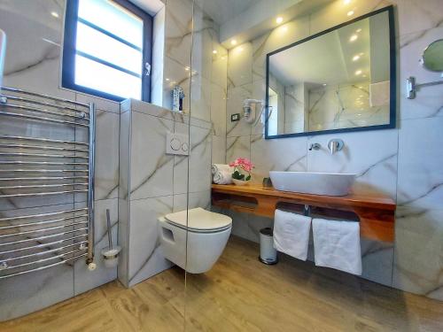 a bathroom with a sink and a toilet and a mirror at Etno Boutique in Plitvička Jezera