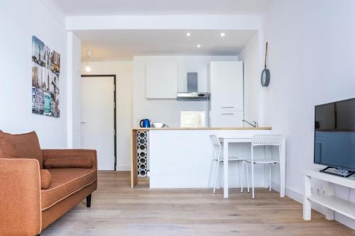 un salon avec un canapé et une cuisine dans l'établissement Bel appartement (2p) en plein Centre d’Antibes, à Antibes