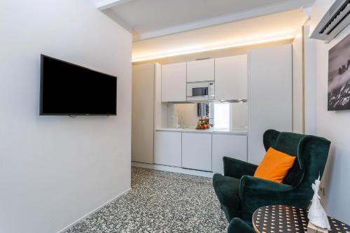 a living room with a television and a chair at Mandello amorevole dimora in Lecco in Lecco