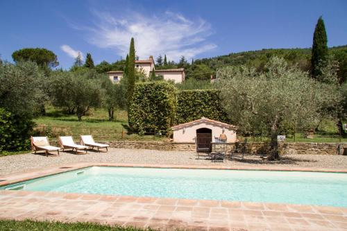 a swimming pool in a yard with a house in the background at Villa Ugo in Cortona