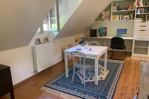 une table blanche et deux chaises dans une pièce dans l'établissement Studio indépendant dans maison neuve, à Senlis