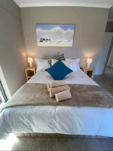 a bedroom with a large white bed with towels on it at Ocean pearl seafront villa in St. Helena Bay