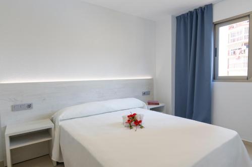 a hospital room with a white bed with flowers on it at Aparthotel BCL Levante Lux in Benidorm