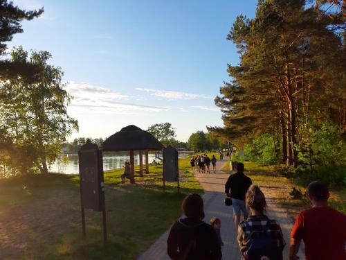 a group of people walking along a path near a lake at Prywatny pokój w Ośrodku Panorama Okuninka in Włodawa