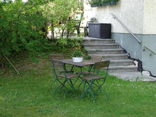 a table with two chairs and a potted plant on it at Pension Bayrhammer in Faistenau
