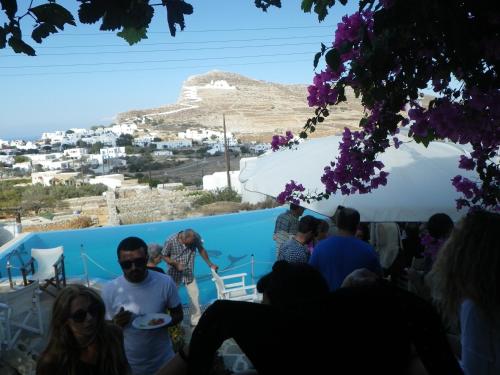 a group of people standing in front of a blue wall at Ampelos in Chora Folegandros