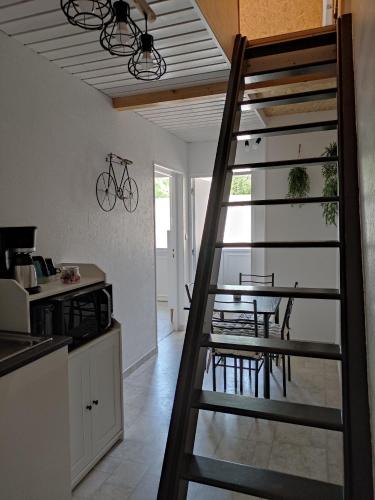 Un escalier mène à une cuisine avec une table. dans l'établissement L'ENTRE-TEMPS, à Chambretaud
