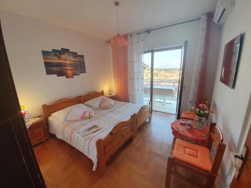 - une chambre avec un grand lit et une grande fenêtre dans l'établissement Apartments Luči, à Hvar