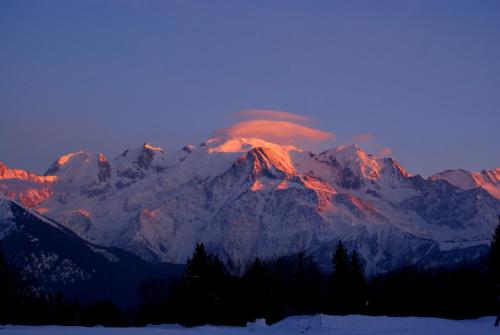 a mountain covered in snow with a sunset at Le Tête Pied Centre/Télécabine Saint-Gervais in Saint-Gervais-les-Bains