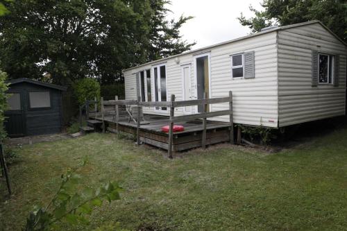 a white trailer with a porch and a red frisbee at CHALET AAN HET STRAND in Nieuwvliet